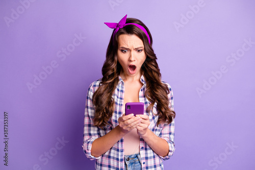 Portrait of her she nice attractive outraged mad worried wavy-haired girl wear checked shirt using cell dislike reaction isolated bright vivid shine vibrant violet lilac pastel color background