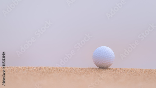 Golf ball lying on sand