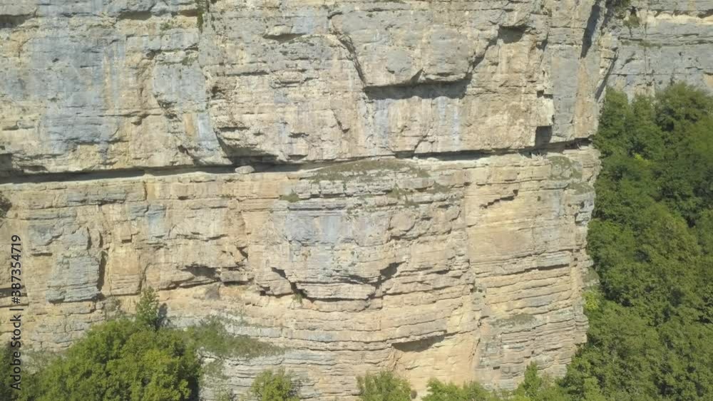 Drone shot flying close to a huge rock cliff. Aerial view on mountain landscape with cliffs. Steep cliff face and mountain line. Drone shot flying close to a huge rock cliff. Aerial view on mountain landscape with cliffs. Steep cliff face and mountain line.