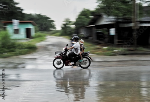 A motorbike is running on a watery road on the road.