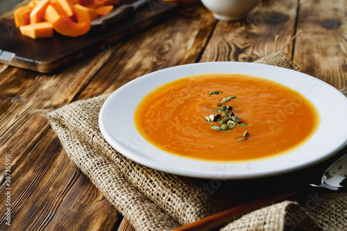 Creamy pumpkin soup on a wooden table