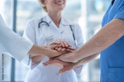 Close-up of medical workers with hands piled up