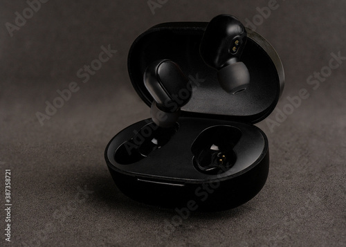 closeup of a pair of floating black wireless headphones on black background