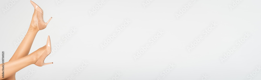 Female legs in air with beige tights and shoes, banner Female legs in air with beige tights and shoes, banner