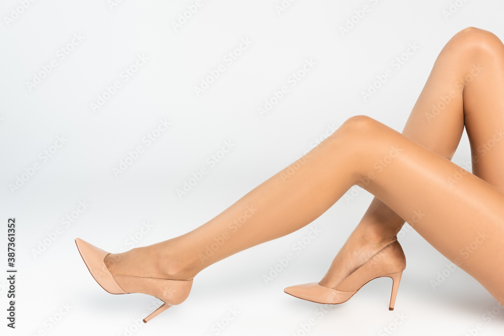 Cropped view of woman sitting, wearing beige tights and shoes Cropped view of woman sitting, wearing beige tights and shoes
