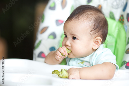 Cute Baby Eating On The Baby Chair