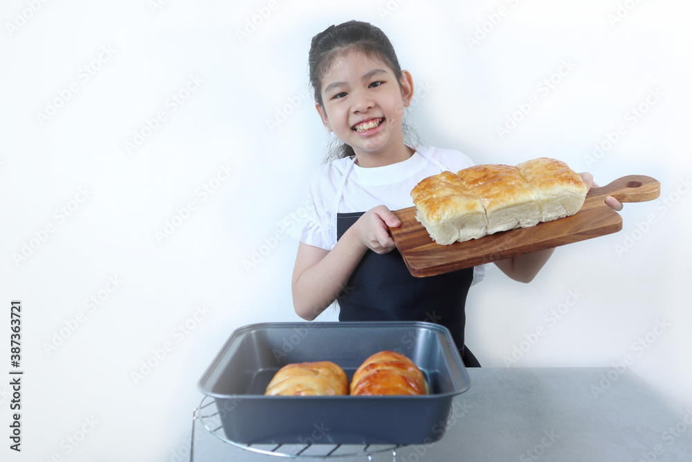 a smiling asian young girl is showing her bread during the baking bakery class lesson in the kitchen with isolated on white background a smiling asian young girl is showing her bread during the baking bakery class lesson in the kitchen with isolated on white background