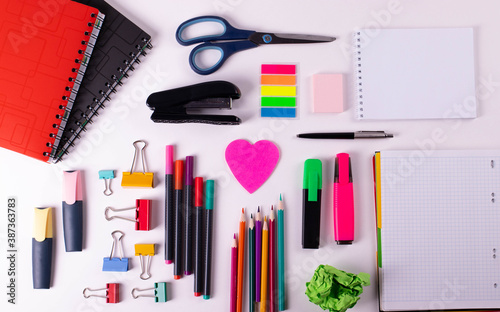 different stationary items of various colours on light surface.