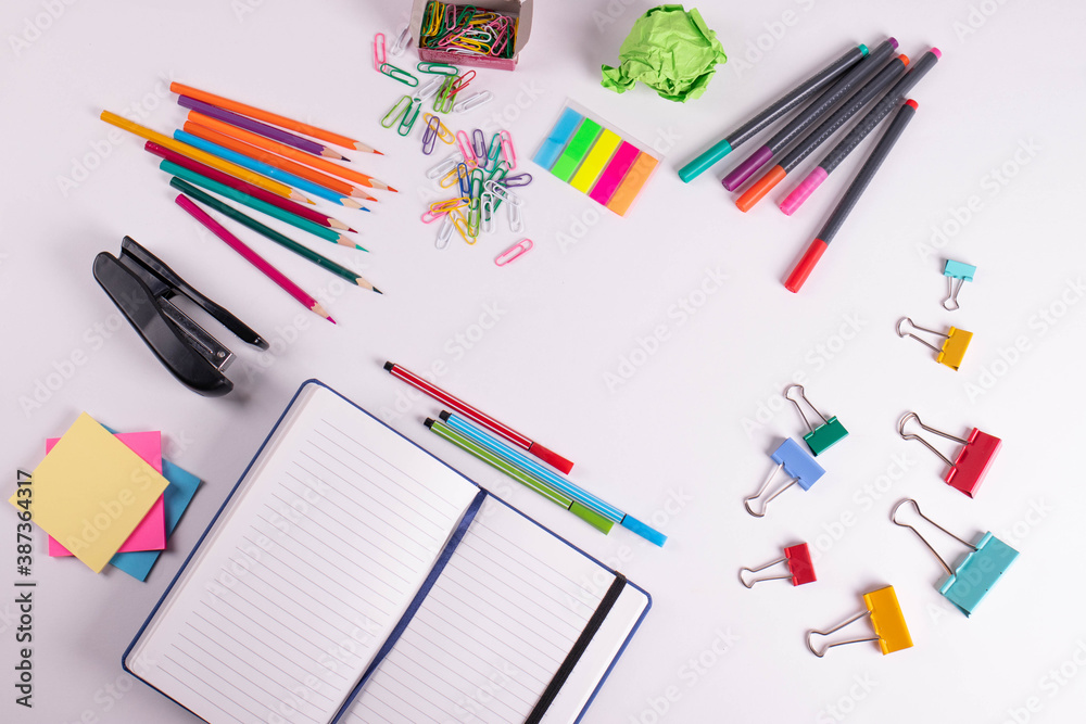 different stationary items of various colours on light surface. different stationary items of various colours on light surface.
