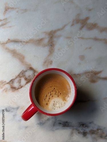 Red expresso cup on a marble countertop..