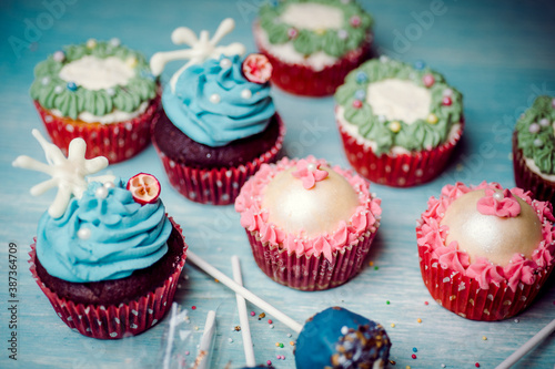 Very nice composition of cupcakes and cakepops with deocrations, colorful, blue background