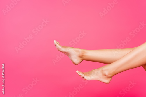 Cropped view of female barefoot legs isolated on pink © LIGHTFIELD STUDIOS
