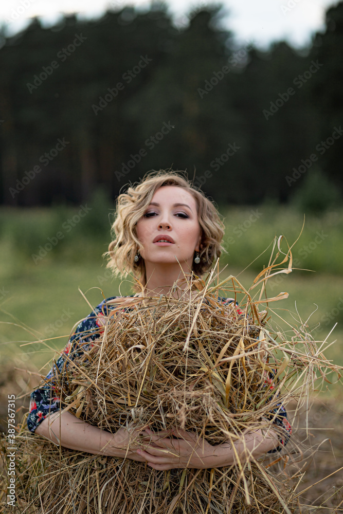 Portrait of a beautiful romantic young woman in the countryside at sunset. young attractive girl in a dress in a rustic style Portrait of a beautiful romantic young woman in the countryside at sunset. young attractive girl in a dress in a rustic style
