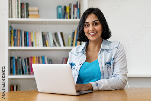 Laughing mexican mature adult woman at computer