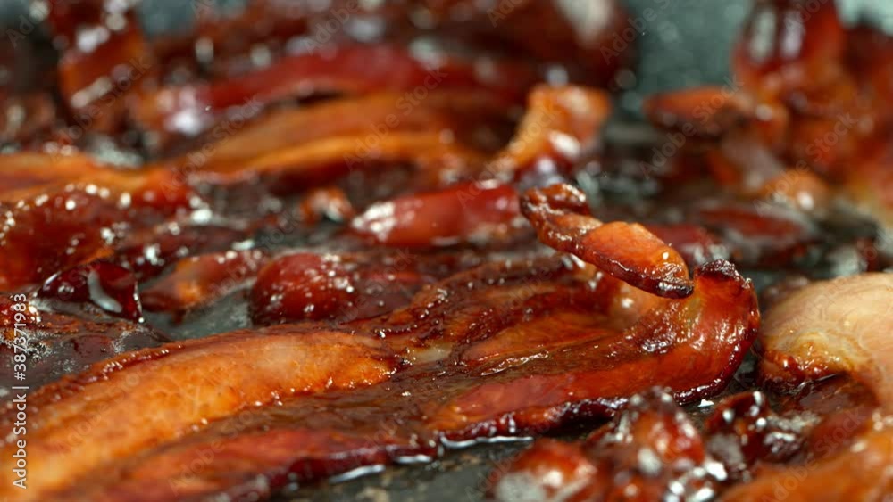 Super Slow Motion Shot of Roasted Bacon Slices Falling into Pan at 1000 fps. Super Slow Motion Shot of Roasted Bacon Slices Falling into Pan at 1000 fps.