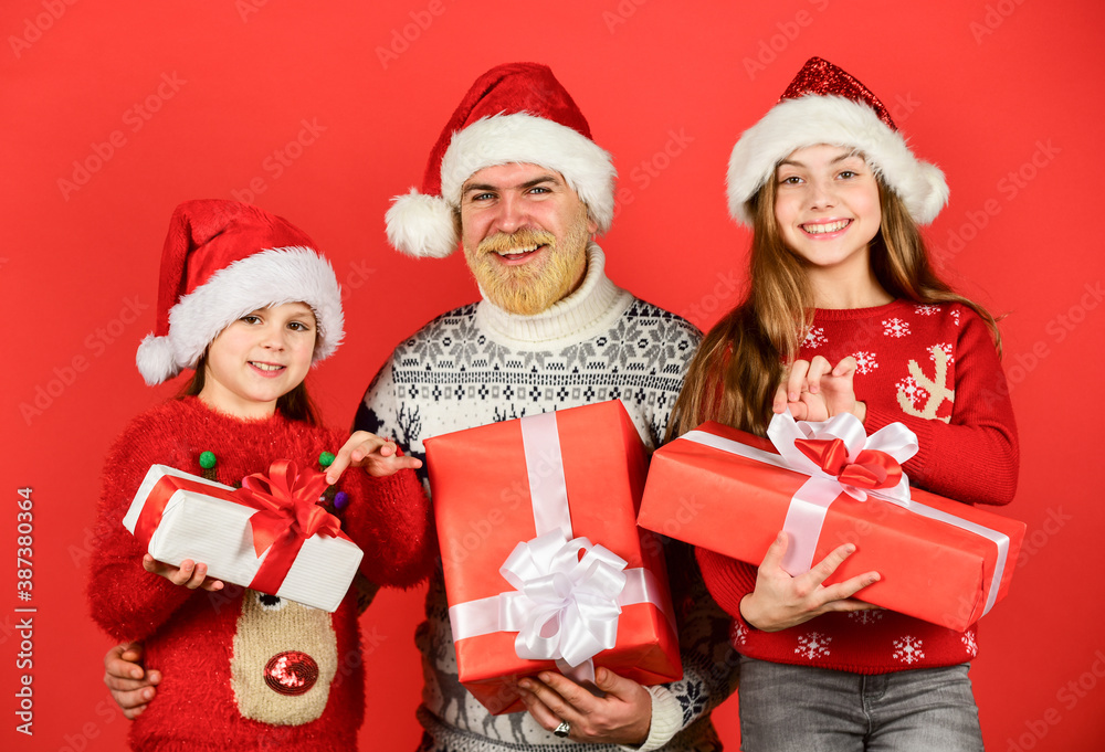 Fototapeta premium delivery christmas gifts. small girls exchange gifts with father. dad love daughters. santa man with kid. knitted fashion for winter. new year shopping. time for presents. happy family celebrate xmas