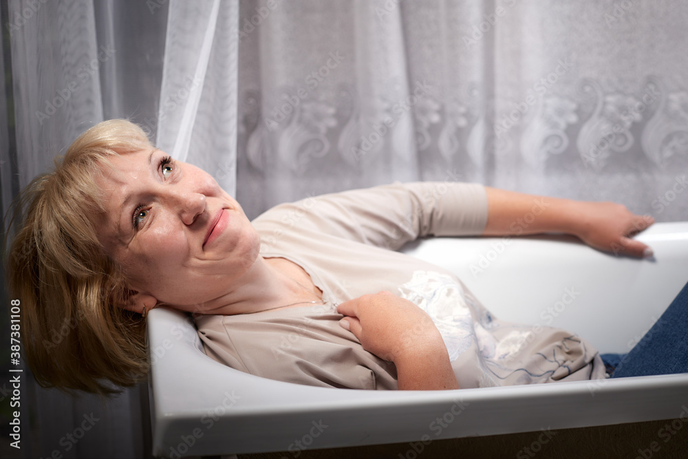 Attractive Old woman with blonde hair in white bath Attractive Old woman with blonde hair in white bath
