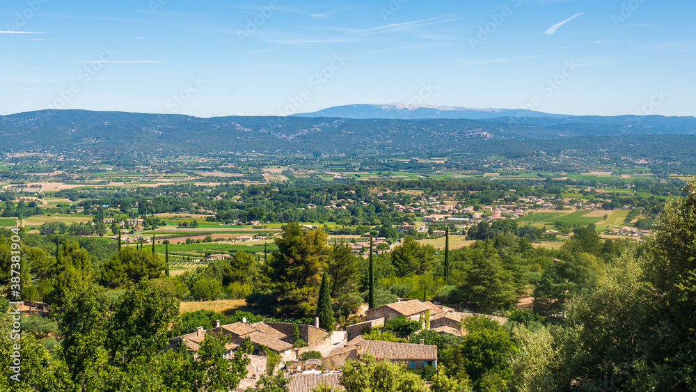 Paysage du lubéron avec vue sur la vallée du rhône, la végétation méditerranéenne et les Alpes à l'arrière plan, un jour ensoleillé sans nuage