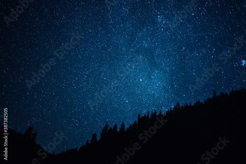 Night sky with stars, satellites. Milky Way passing in long exposure. Beautiful panorama view with rock, mountain. Nature, universe, galaxy, astronomy concept.
