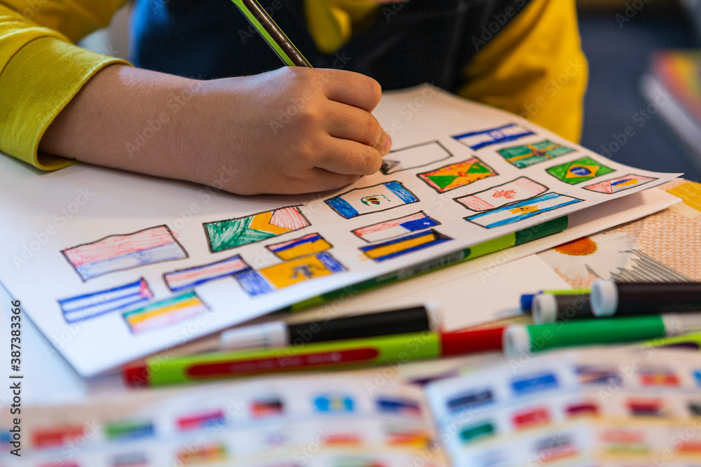 child draws flags of world countries at home. child draws on a white sheet at home in natural light geographical areas of world countries.
child draws flags of world countries at home. child draws on a white sheet at home in natural light geographical areas of world countries.