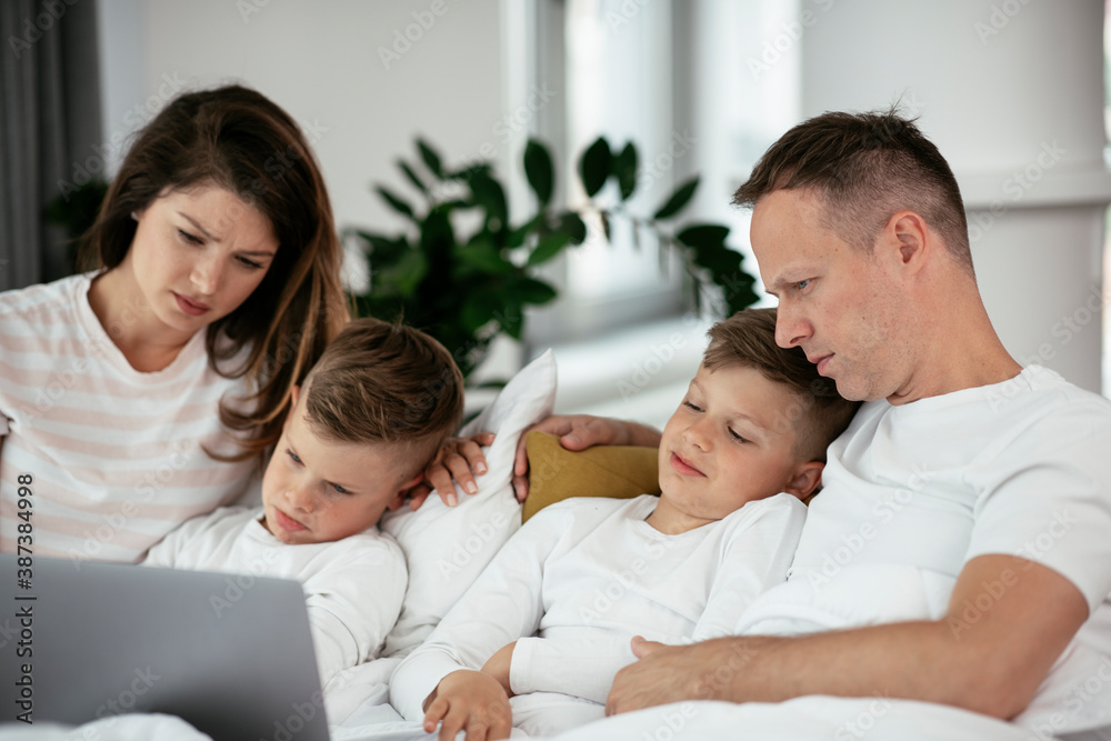 Beautiful parents with kids enjoying at home. Young family watching movie on lap top. Beautiful parents with kids enjoying at home. Young family watching movie on lap top.