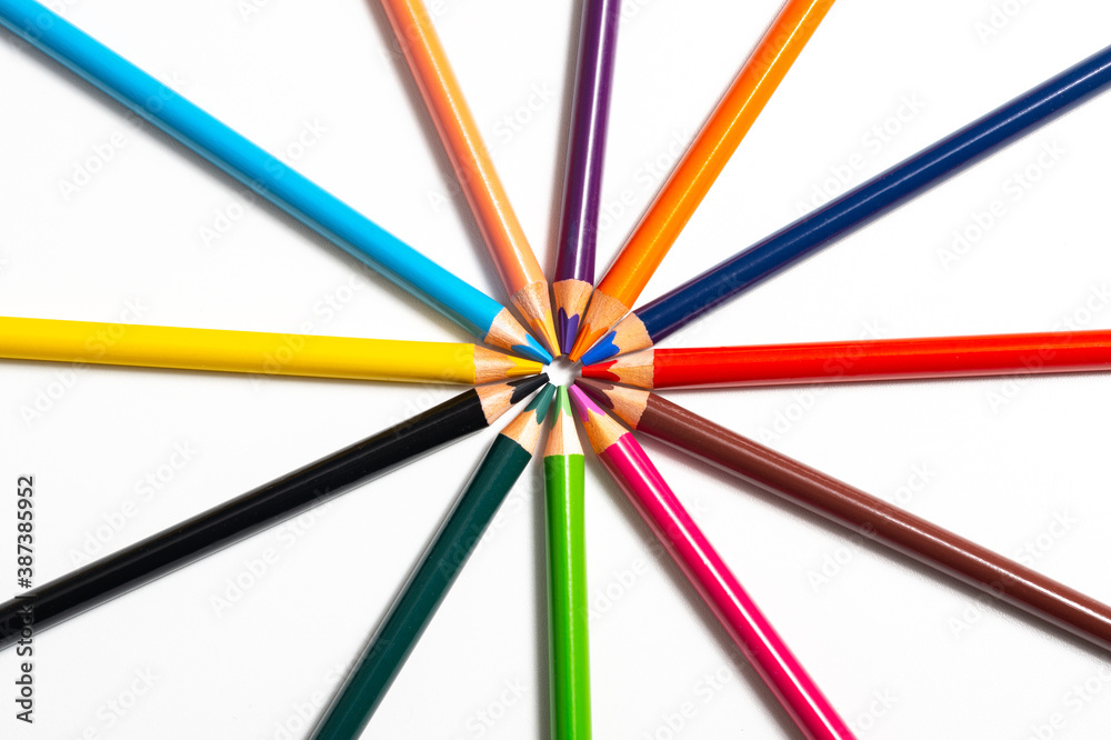 Buntstifte in verschiedene Farben aufgereiht auf weißen Hintergrund