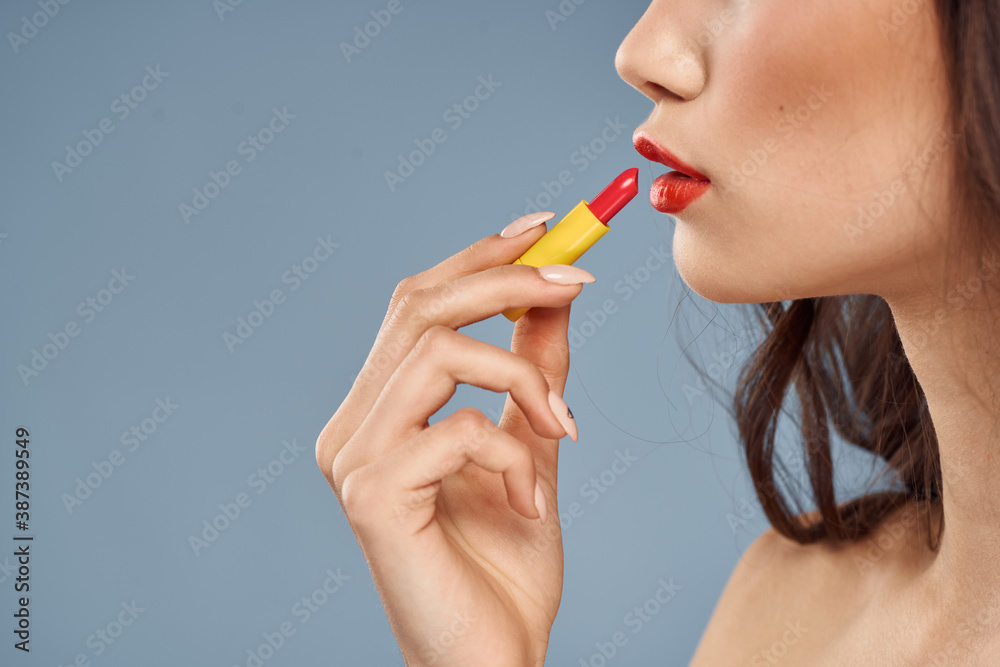 Woman with lipstick on a gray background brunette makeup with eye shadow on the eyelids Woman with lipstick on a gray background brunette makeup with eye shadow on the eyelids