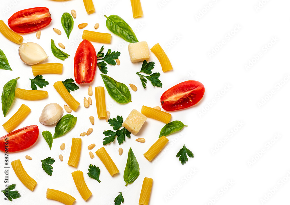 pasta, greens, pine nuts, slices of tomato, cheese and garlic on a white background. space for text on the right pasta, greens, pine nuts, slices of tomato, cheese and garlic on a white background. space for text on the right