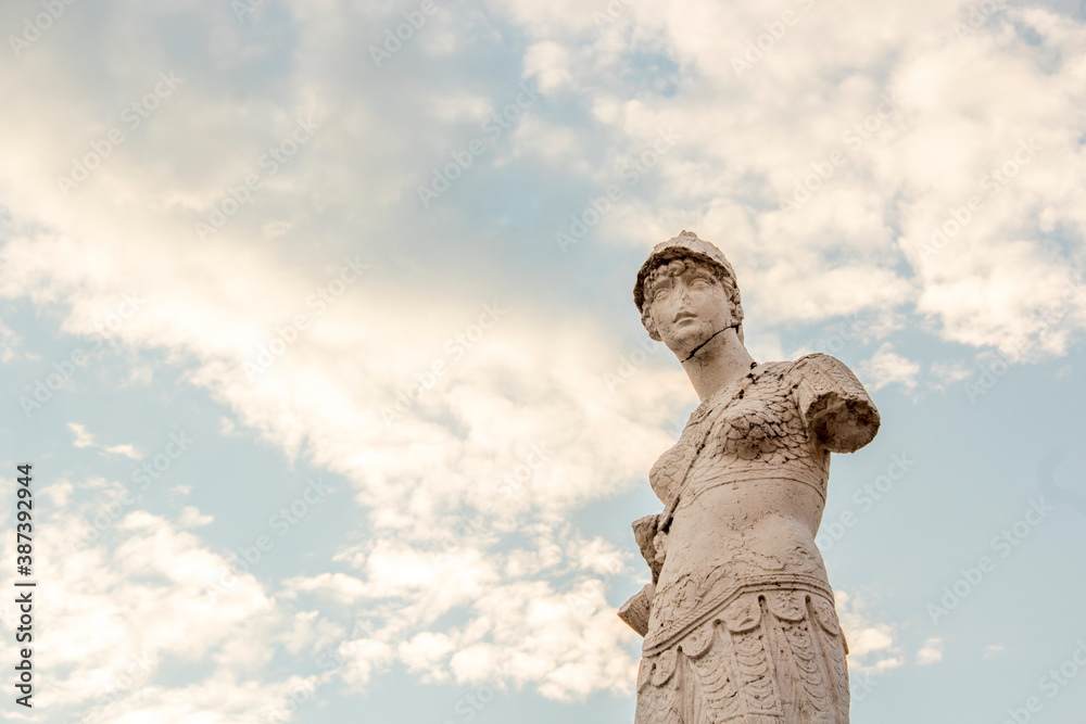 Close up, minerva statue of Brescia. Cloudy clear sky in background with sunrays at sunset moment. Lombardy region - Italy