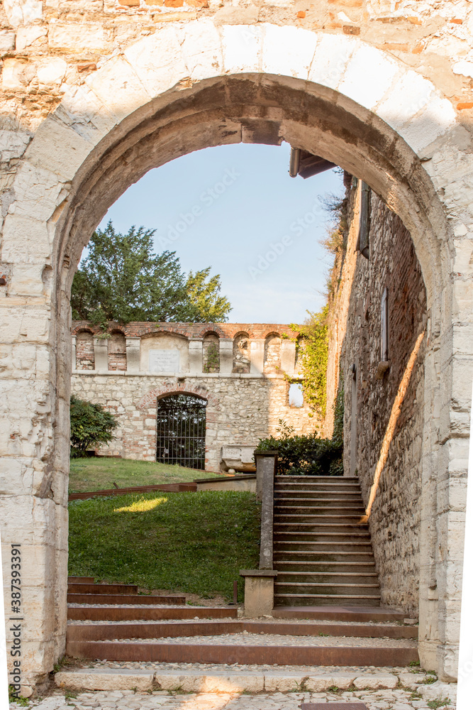 Naklejka premium Close up. Medieval castle (Castello di Brescia) with battlements, a tower, drawbridge and ramparts. Lombardy, Italy