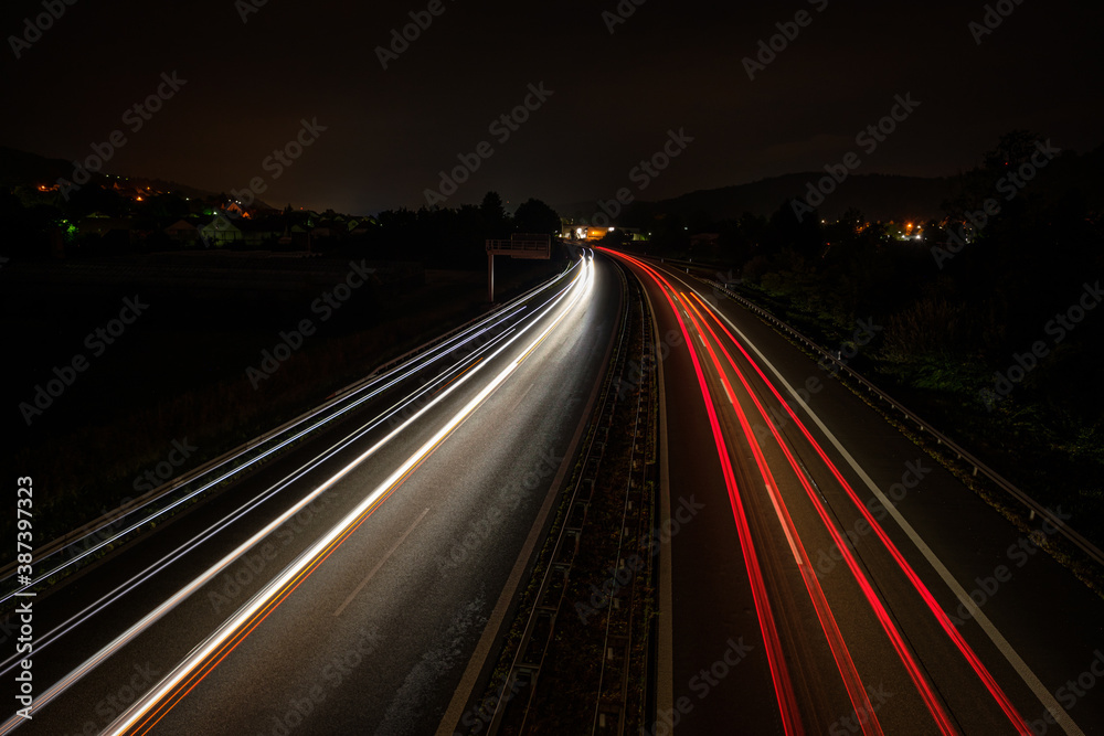 Motorway in night with red and white car light trails