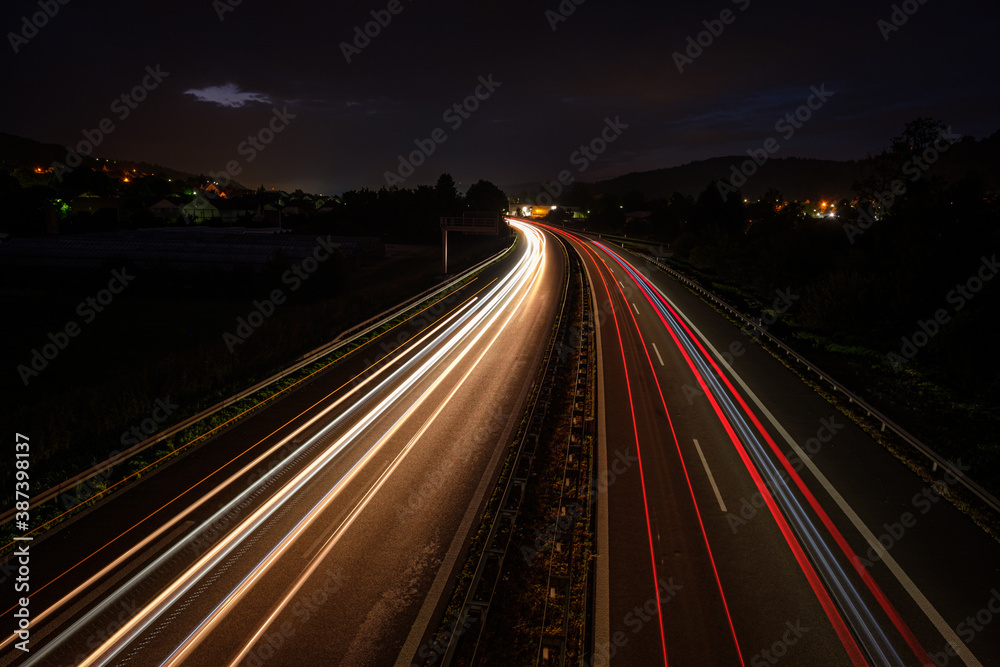 Many light trails in night of cars and trucks
