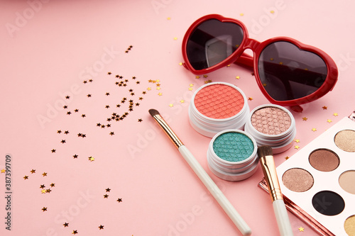 eyeshadow accessories beads makeup brushes collection professional cosmetics on pink background