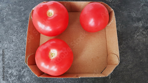 Tomatoes in a box on a dark background