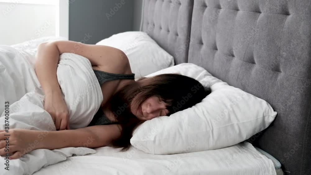 Woman suffering from insomnia at home. Lying in bad trying to fall asleep without luck. Sad and exhausted person during sleepless night. Woman suffering from insomnia at home. Lying in bad trying to fall asleep without luck. Sad and exhausted person during sleepless night.