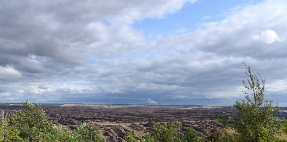 Karge Abraumlandschaft des Braunkohle-Tagebaus in Welzow unter dramatischem Himmel