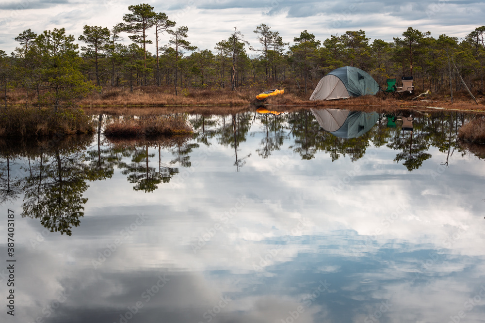 Obraz premium Tents near forest lake in day and night time