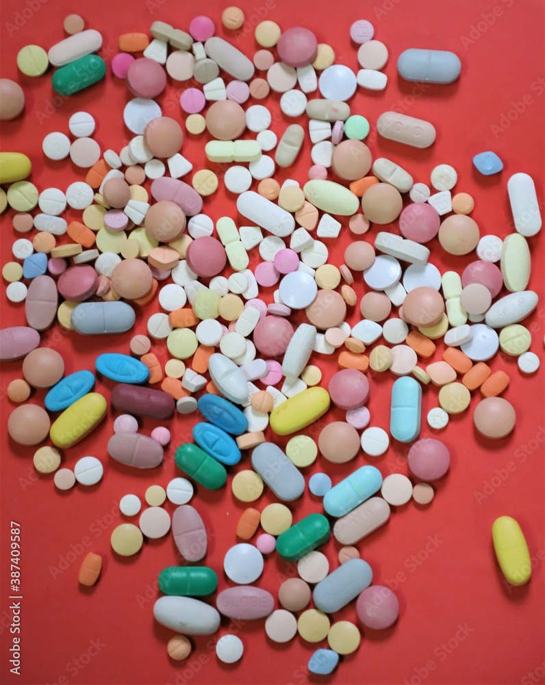 pills and capsules over red surface