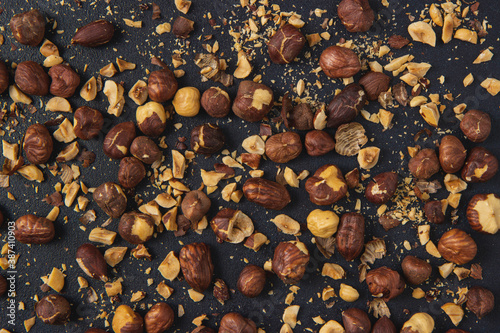 Background image of roasted hazelnuts isolated on the dark background. Roasted Hazelnuts.