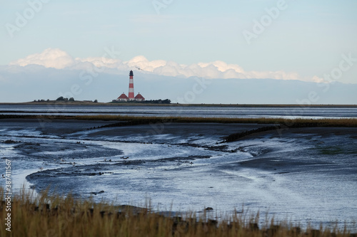 Ebbe in der Nordsee mit einem Leuchtturm in Westerhever/D im Hintergrund