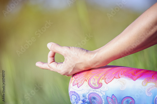 Portrait of gorgeous young woman practicing yoga with nature background.