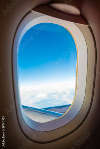 Beautiful clouds and sky as seen through window of an airplane, evening time