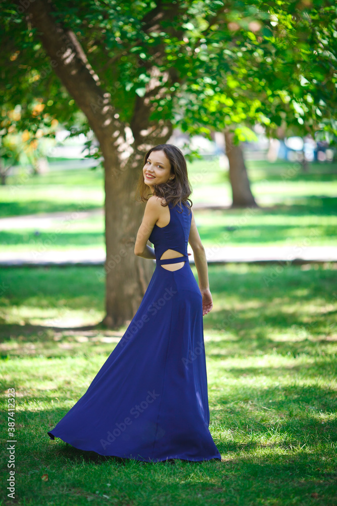 Girl in a blue dress walks in the park Girl in a blue dress walks in the park