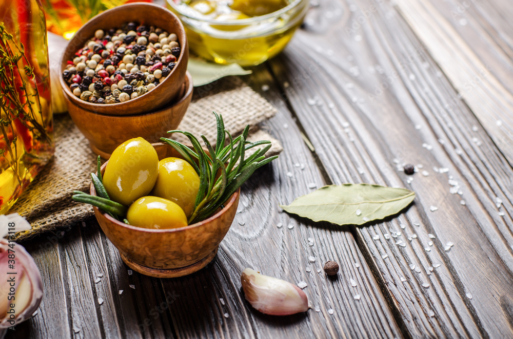 Closeup view of green olives oils and spices on kitchen table. Cooking concept