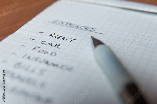 Fotografie List of daily living expenses, with a pen next to it.