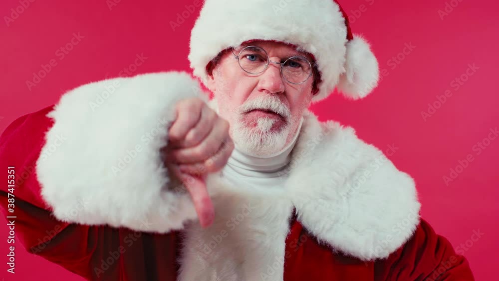 displeased santa claus showing thumb down isolated on red displeased santa claus showing thumb down isolated on red