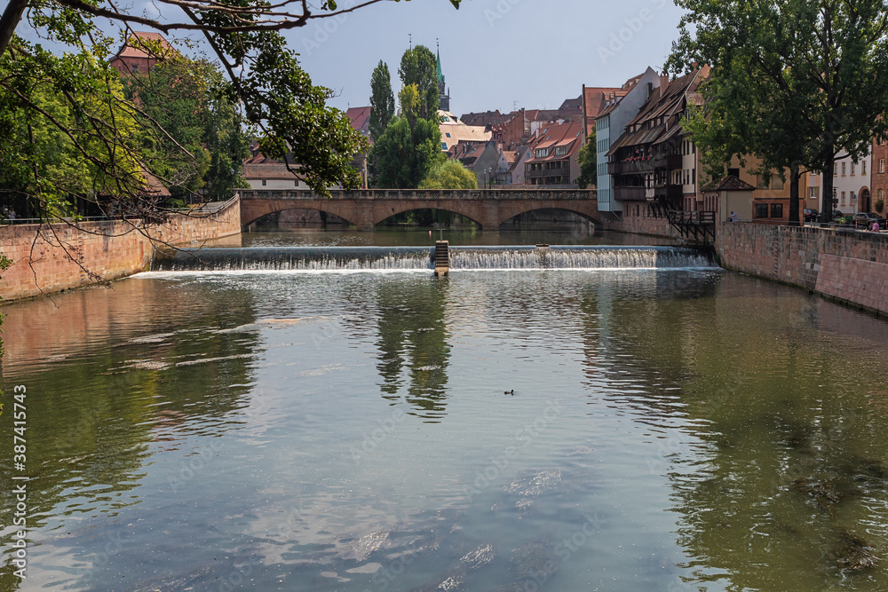 Naklejka premium Walking over the Pegnitz River in Nuremberg near the Haller Gate Bridge