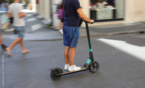 riding an electric kick scooter on the road