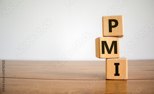Concept word 'PMI - purchasing manager index' on cubes on a beautiful wooden table. White background. Business concept. Copy space. photo