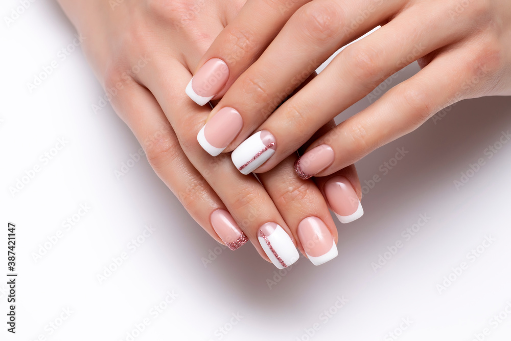 French wedding white manicure with pink glittery stripe and shiny little finger on long square nails close-up on white background French wedding white manicure with pink glittery stripe and shiny little finger on long square nails close-up on white background